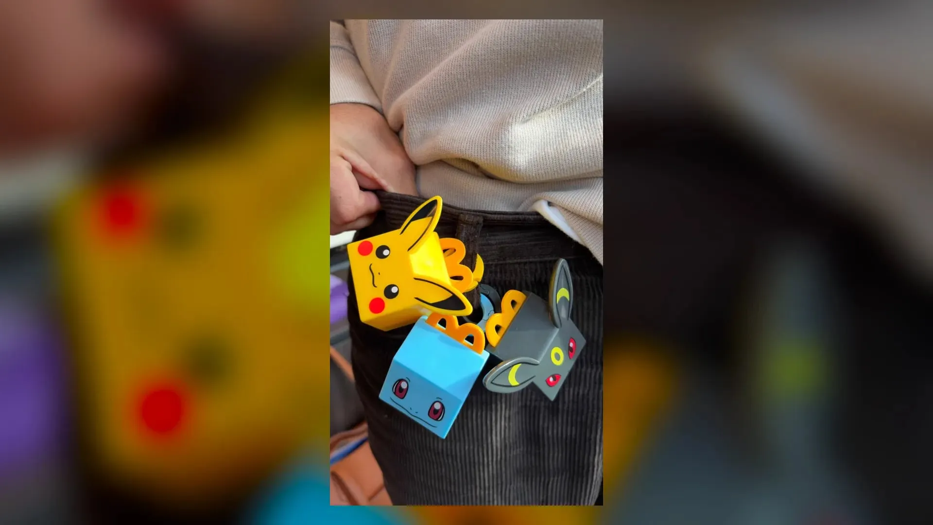 McDonald's Pokémon mini Happy Meal box toys shaped like Pikachu, Squirtle and Umbreon clipped to a pair of trousers