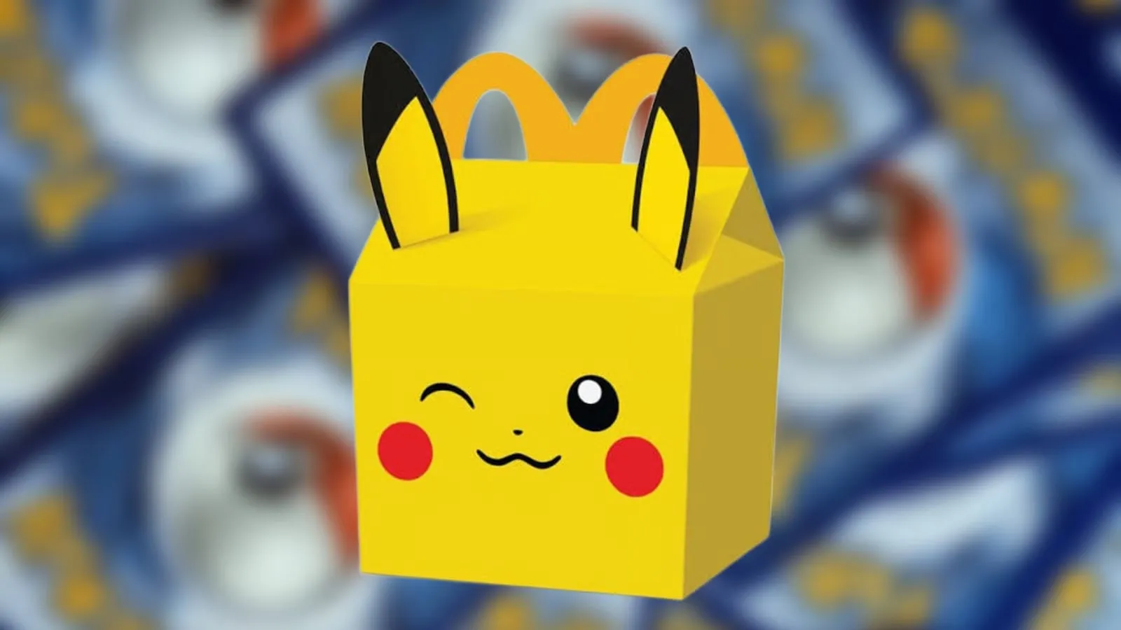 A Pikachu-themed McDonald’s Happy Meal box in front of blurred Pokémon cards